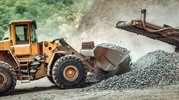 Cargador frontal operando en movimiento de tierra pesado, representativo del sector de construcción