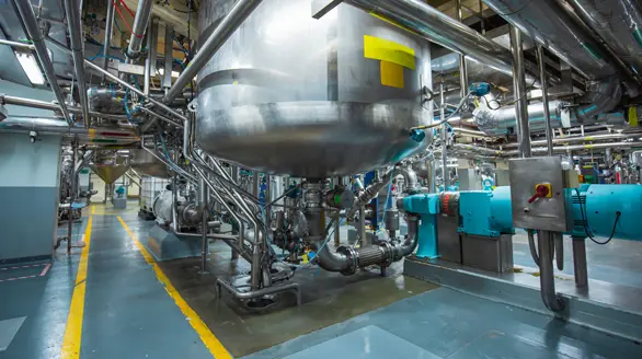 Complejo de tuberías de acero inoxidable, tanques de mezcla y bombas industriales en una planta de procesamiento químico
